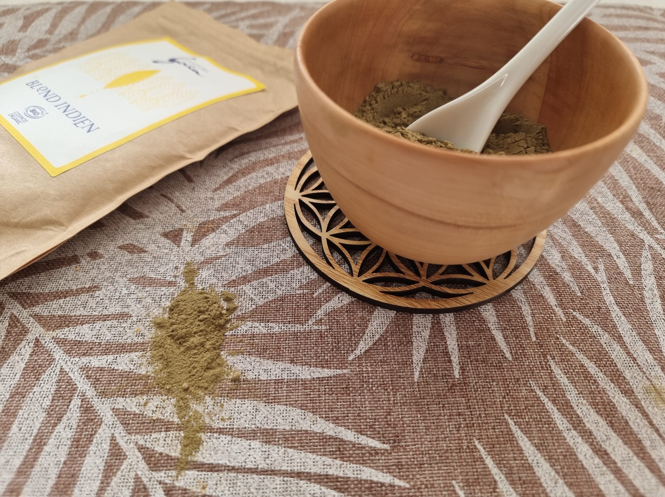 Une coupelle en bois qui contient de la poudre de plantes pour la coloration végétale